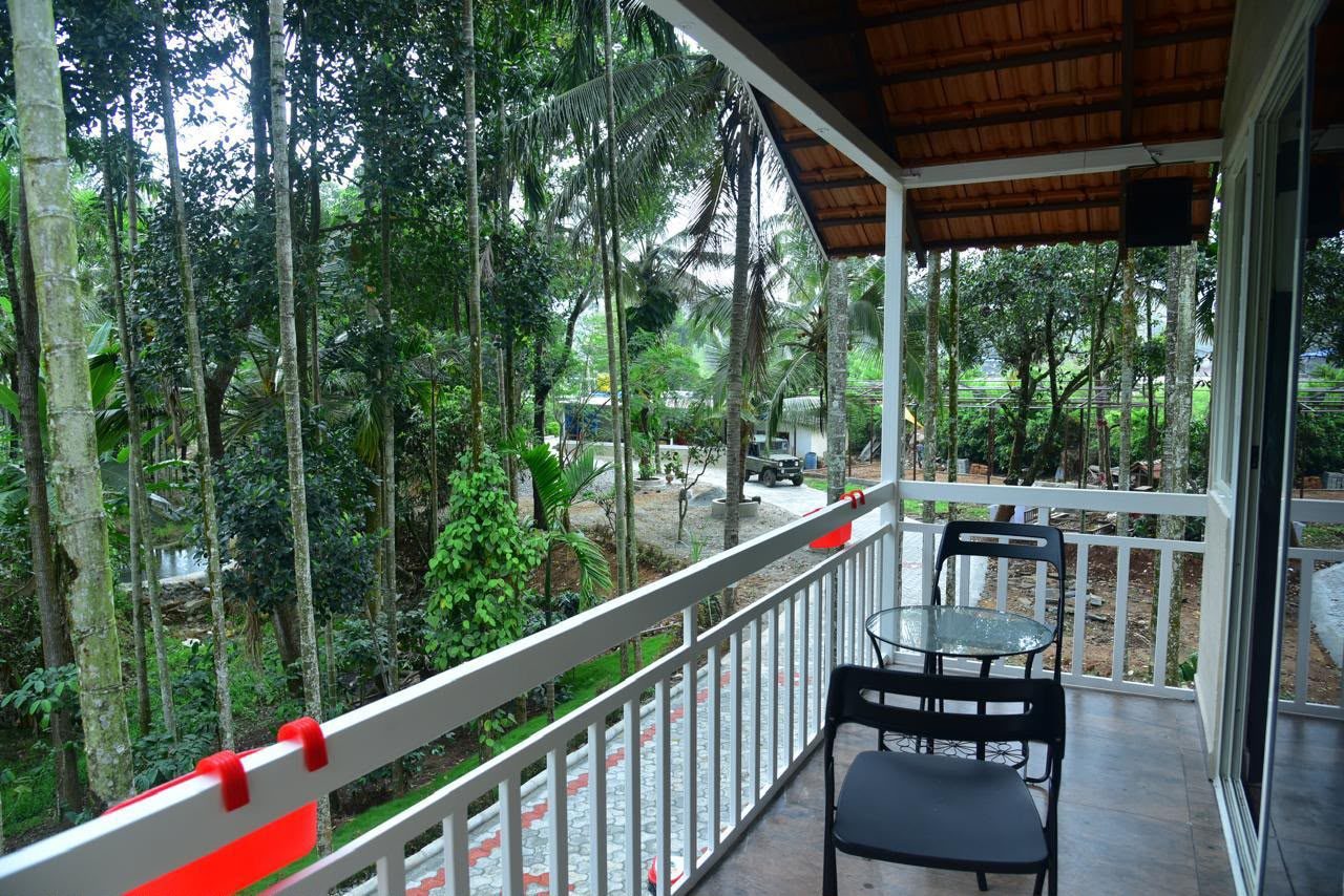 A private balcony with a table and chairs overlooking the trees