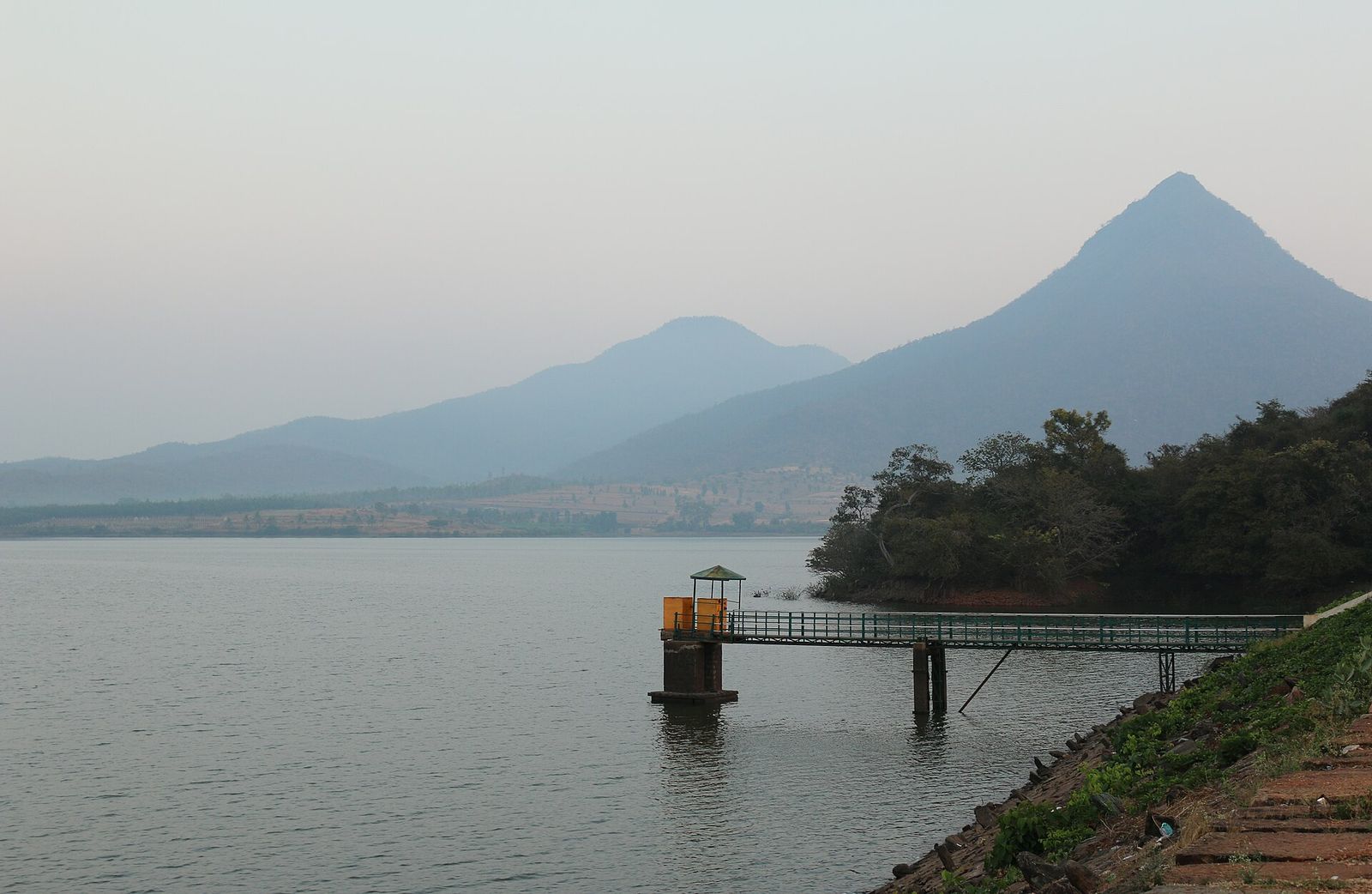 Ayyanakere Lake with a small jetty and a pointed hill beyond