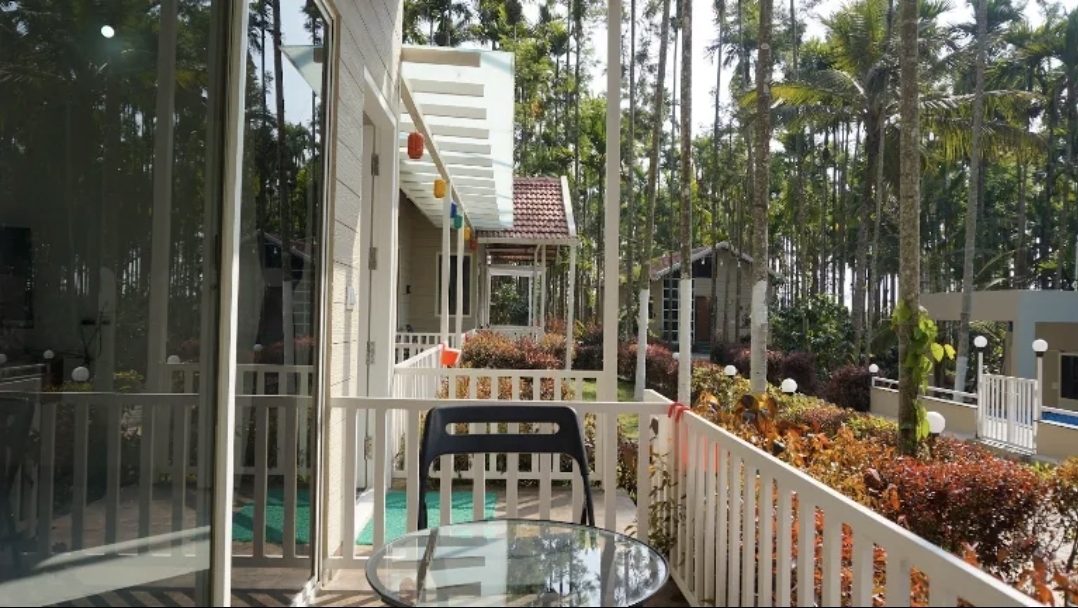 A verandah with a glass table, looking along the cottages to the garden